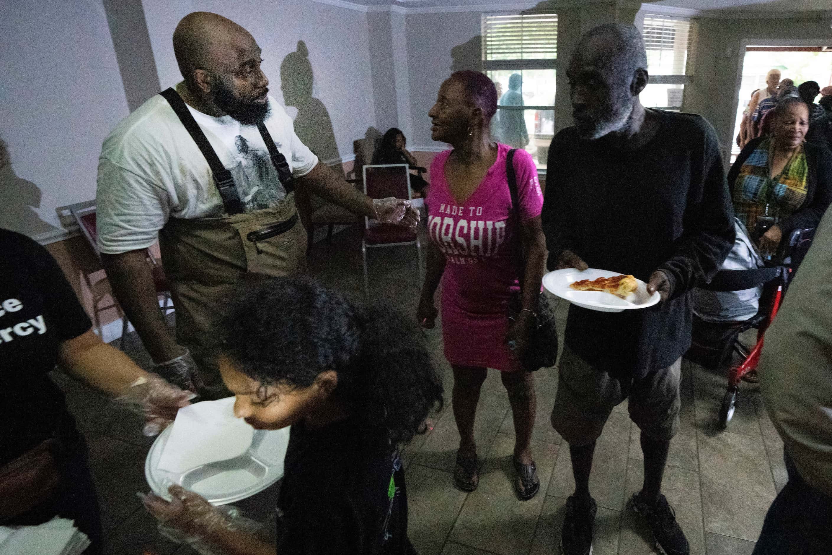 Rap artist Trae the Truth and his ReliefGang serves pizza to residents at Pleasant Hill...