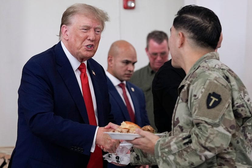 Republican presidential candidate and former President Donald Trump, left, helps serve food...