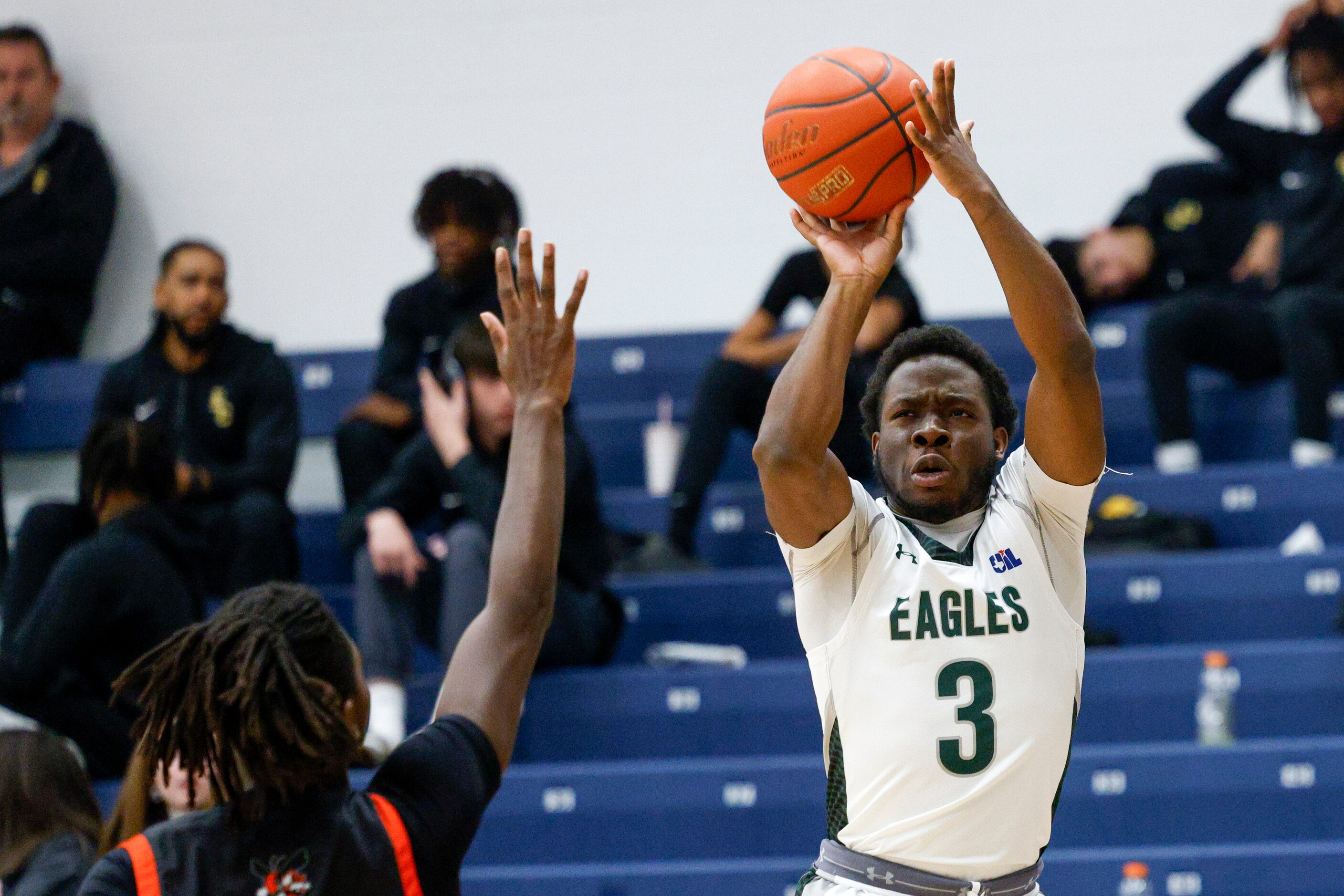 Mansfield Lake Ridge's Ehi Akharoh (3) shoots over a Rockwall defender during the first half...