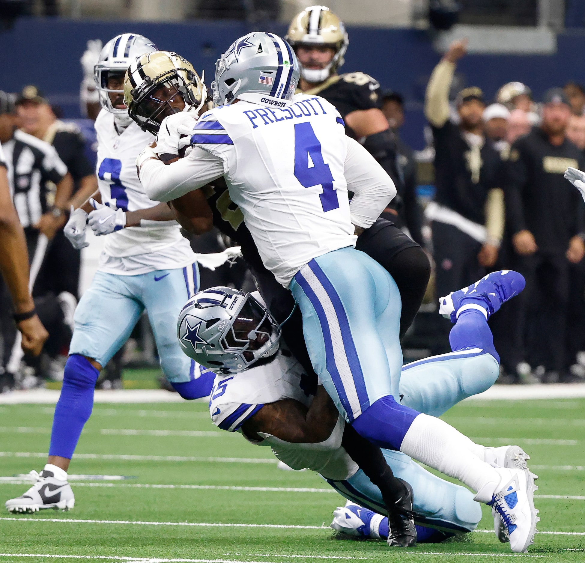 Dallas Cowboys quarterback Dak Prescott (4) and running back Ezekiel Elliott (15) bring down...