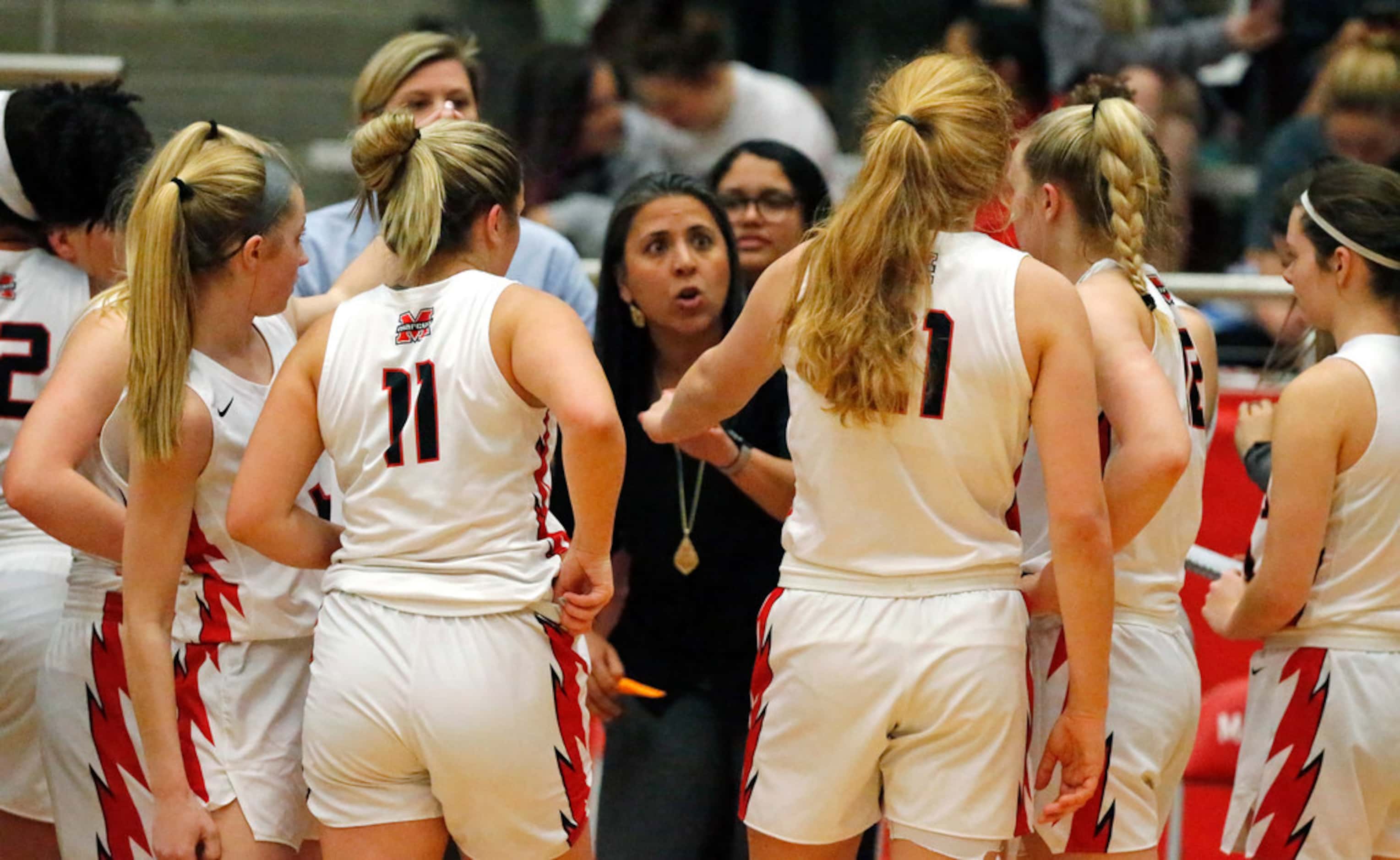 Flower Mound Marcus High School head coach Monica Pena talks to her team during a time out...