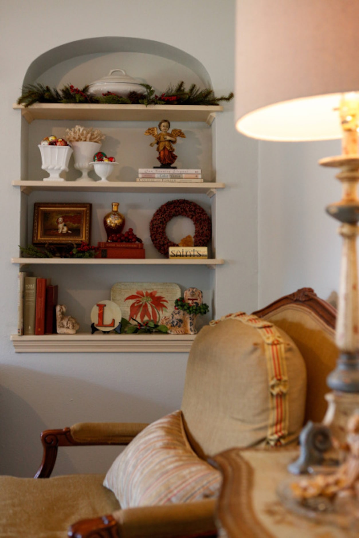 Larger arched bookcase in the den isnÕt left out of the holiday fun: Pops of red from plates...