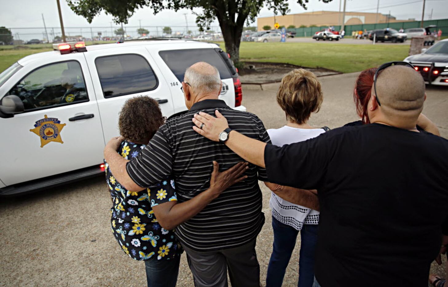 People comforted one another as a processional for DART Police Officer Brent Thompson pulled...