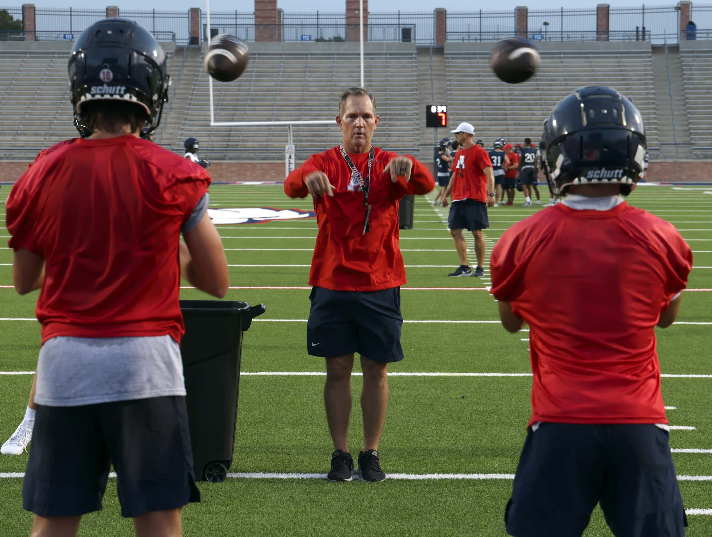 Allen head football coach Lee Wiginton exhibits great ball skills as he delivers two spirals...