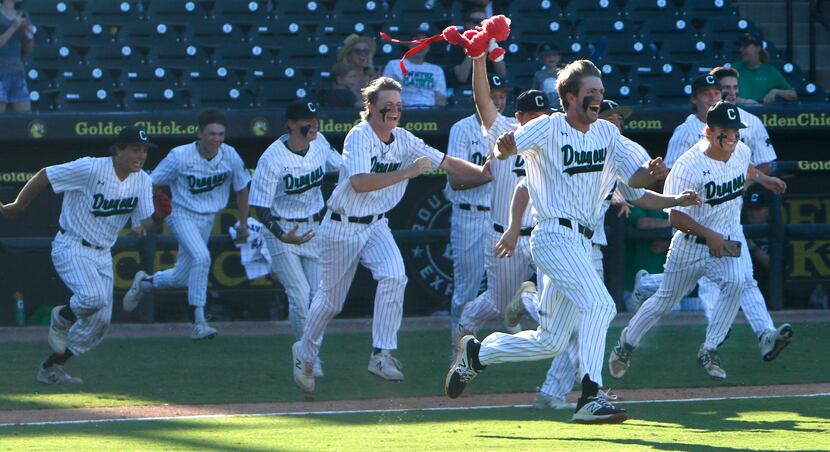 Members of the Southlake Carroll Dragons bolt onto the field following the final out in...