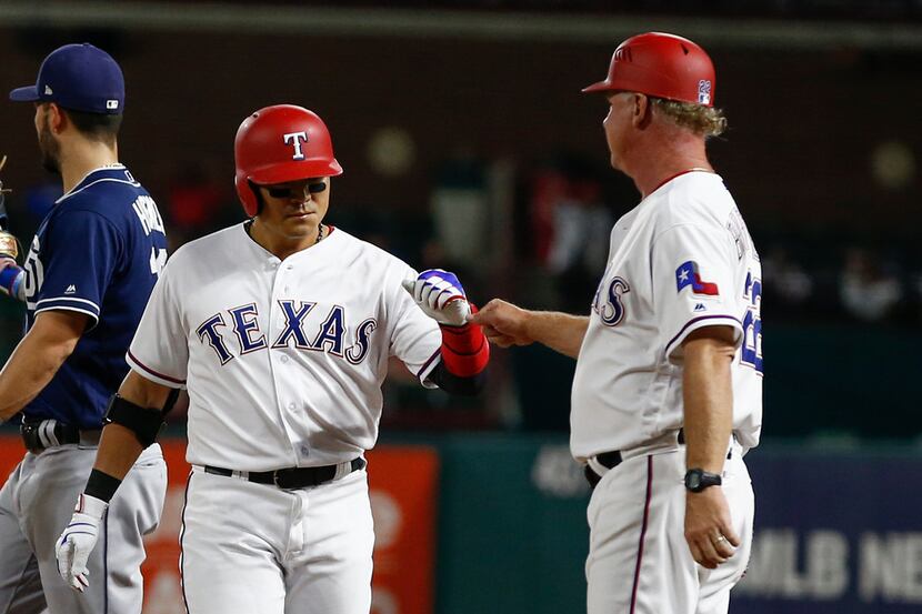 Texas Rangers' Shin-Soo Choo, left, celebrates his base hit with hitting coach Steve...