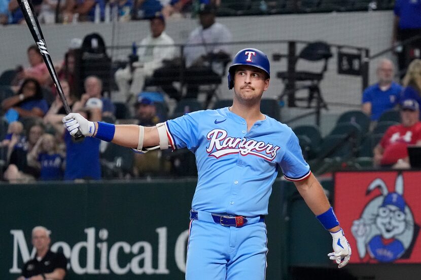 Texas Rangers' Nathaniel Lowe reacts after striking out swinging during the ninth inning of...