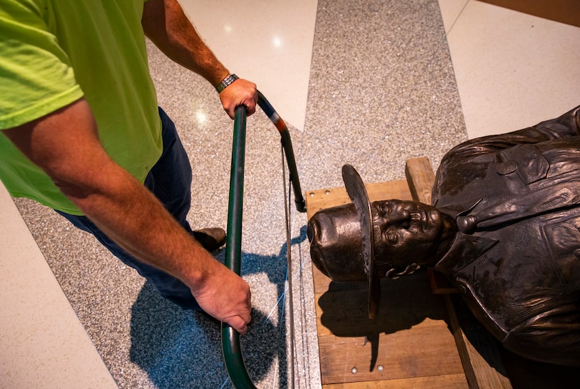 The crew removes 'One Riot, One Ranger' from the main lobby inside Love Field airport on...