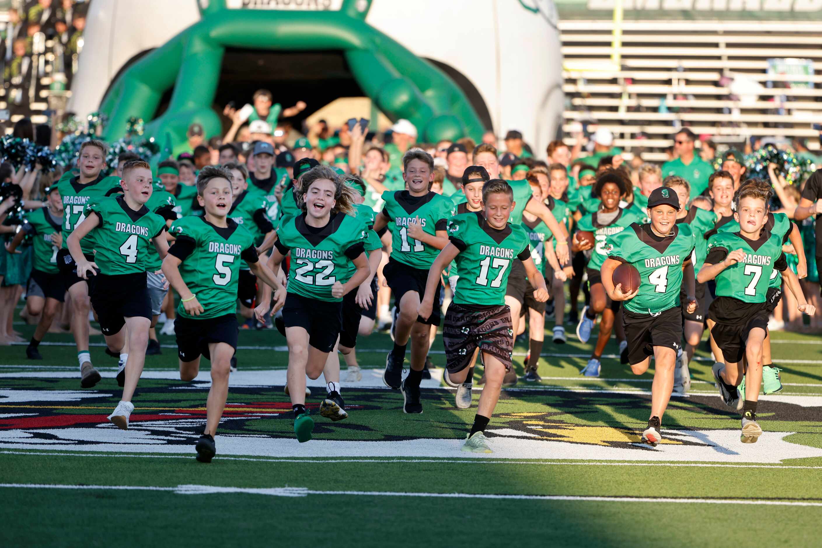 Southlake Youth Football players run onto the field prior to Southlake playing Arlington...