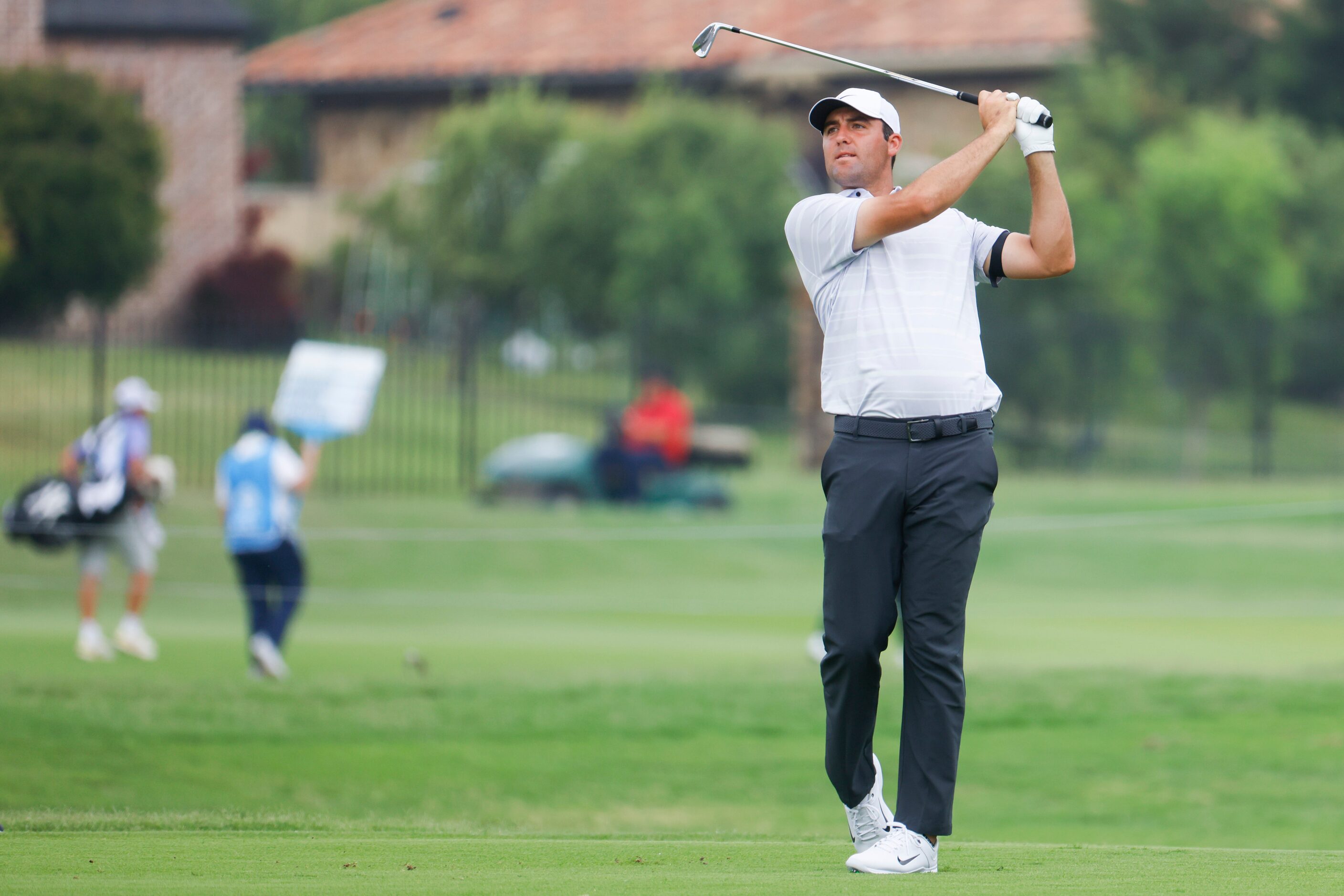 Scottie Scheffler of United States watches as he hits on the green of the ninth hole during...