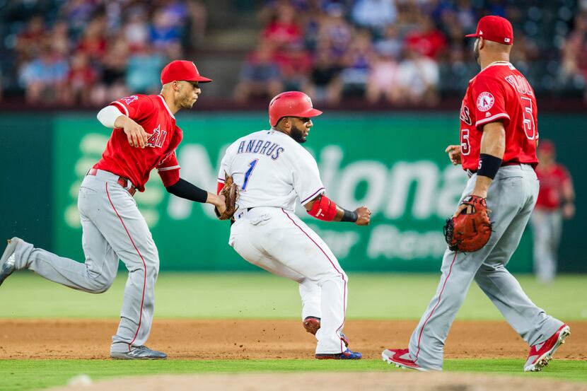 Texas Rangers shortstop Elvis Andrus (1) is tagged out between first and second base by Los...