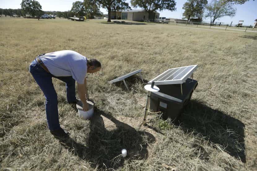 Scott Passmore, director of public works, checks on a solar-powered seismic monitor that...