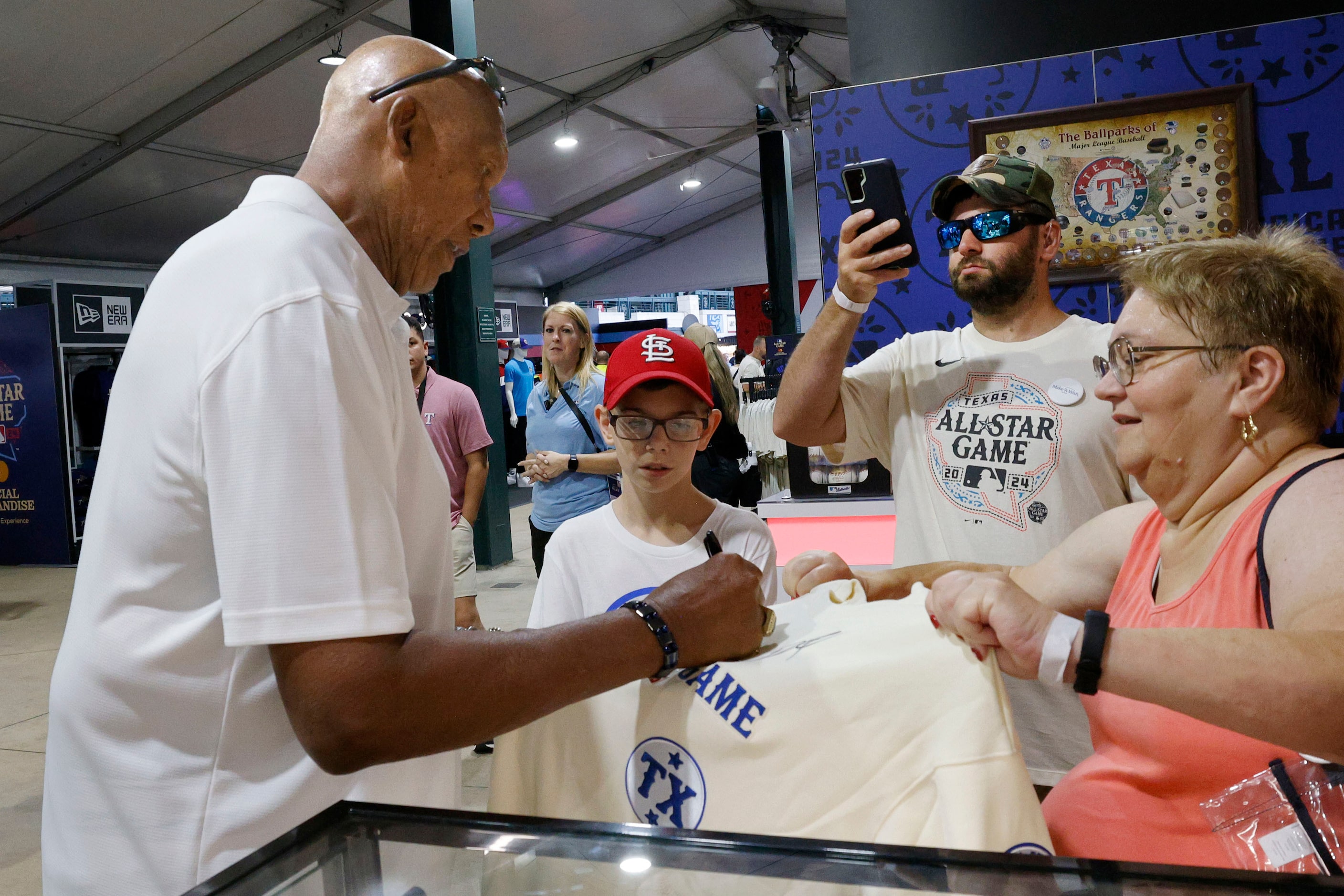 Former Texas Rangers and Chicago Cubs pitcher Ferguson Jenkins, left, autographs a shirt for...