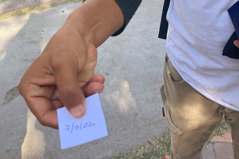 Un migrante muestra un papel con la fecha en que fue citado por la Casa del Migrante de...