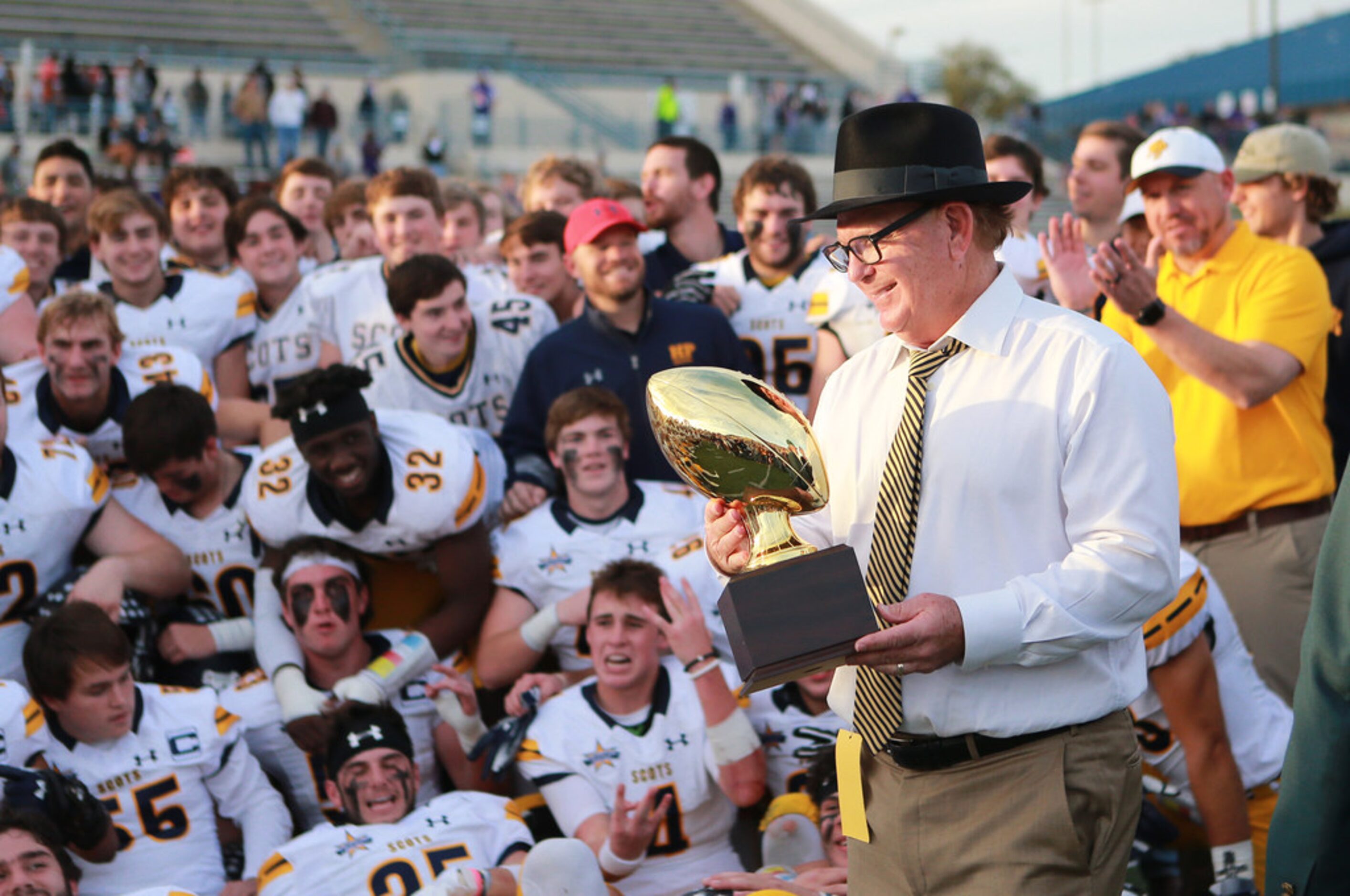 Highland Park football head coach Randy Allen bringing the trophy to Highland Park football...