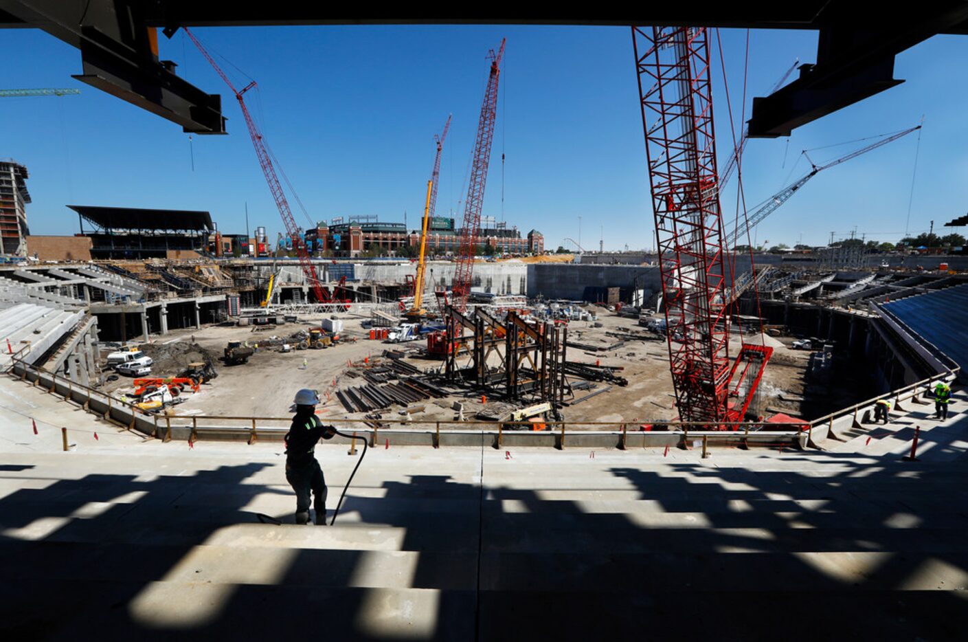 Construction worker Tevin Bias winds up a cord as he works on the main concourse seating...