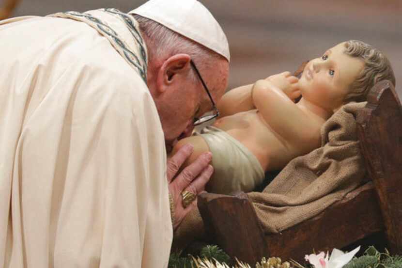 El papa Francisco besa una imagen del Niño Dios durante una misa de víspera de Año Nuevo en...