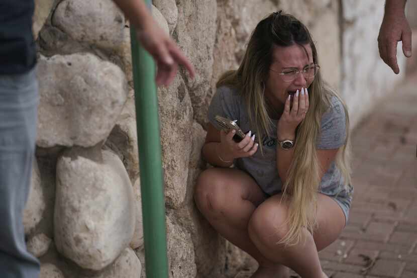 Israelis take cover from incoming rocket fire from the Gaza Strip in Ashkelon, southern...