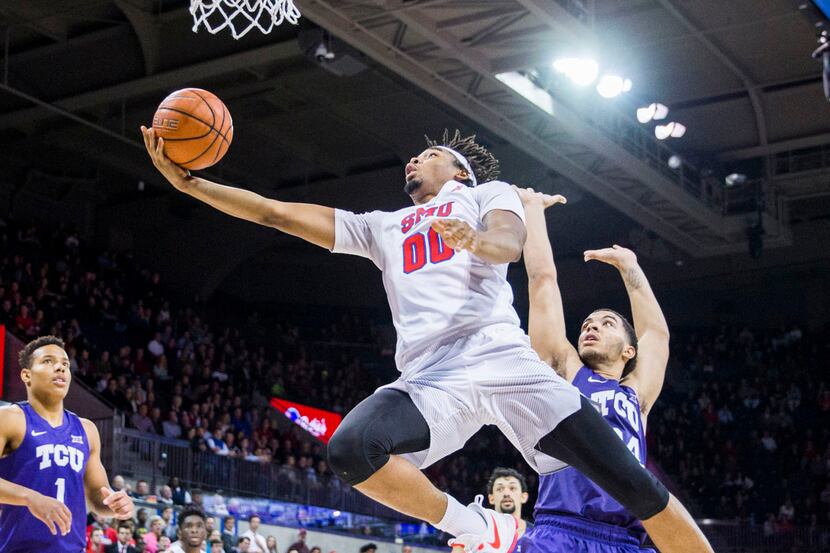 Southern Methodist Mustangs forward Ben Moore (0) goes up for a shot over TCU Horned Frogs...