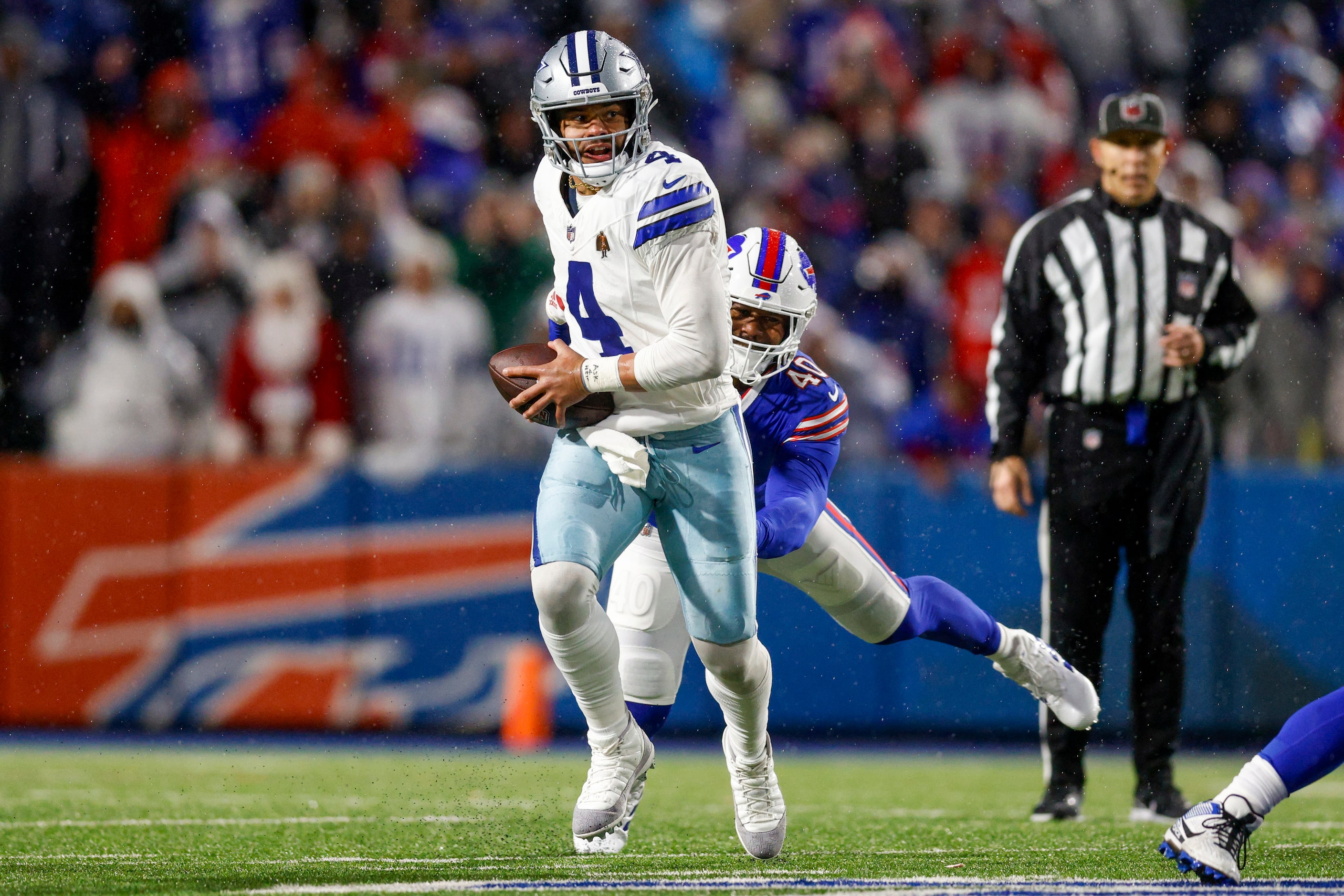 Dallas Cowboys quarterback Dak Prescott (4) slips a sack attempt from Buffalo Bills...