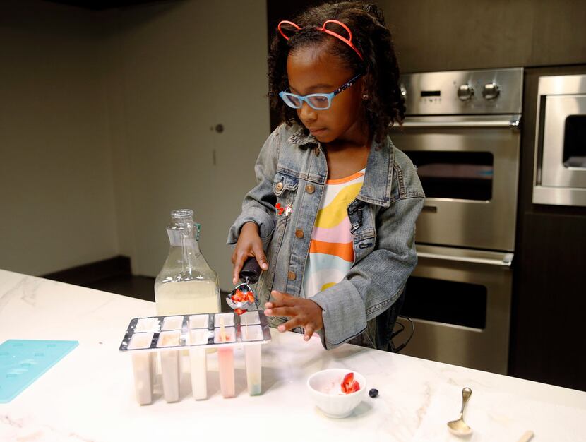 Ellington Young, 7, makes a strawberry and lemonade ice pop.