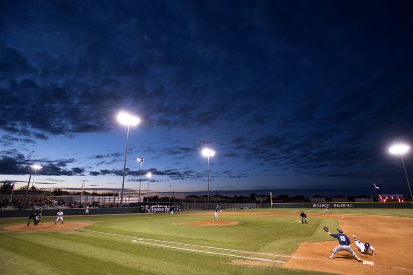 Night falls during the second inning of a high school baseball game between McKinney North...