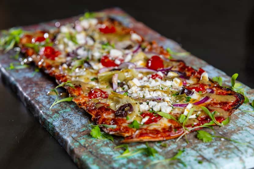 Mediterranean flatbread pizza made with marinara sauce, olives, tomatoes, red pepper, garlic...