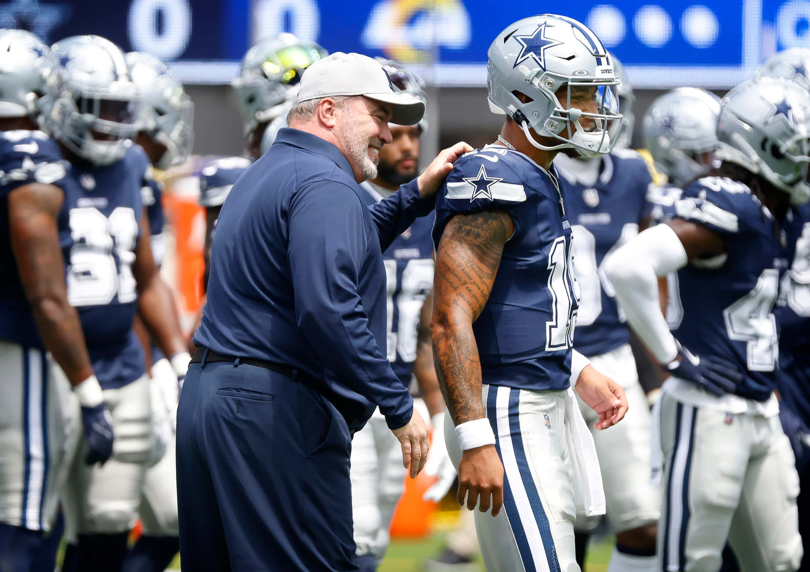 Dallas Cowboys head coach Mike McCarthy taps his quarterback Trey Lance on the shoulder as...