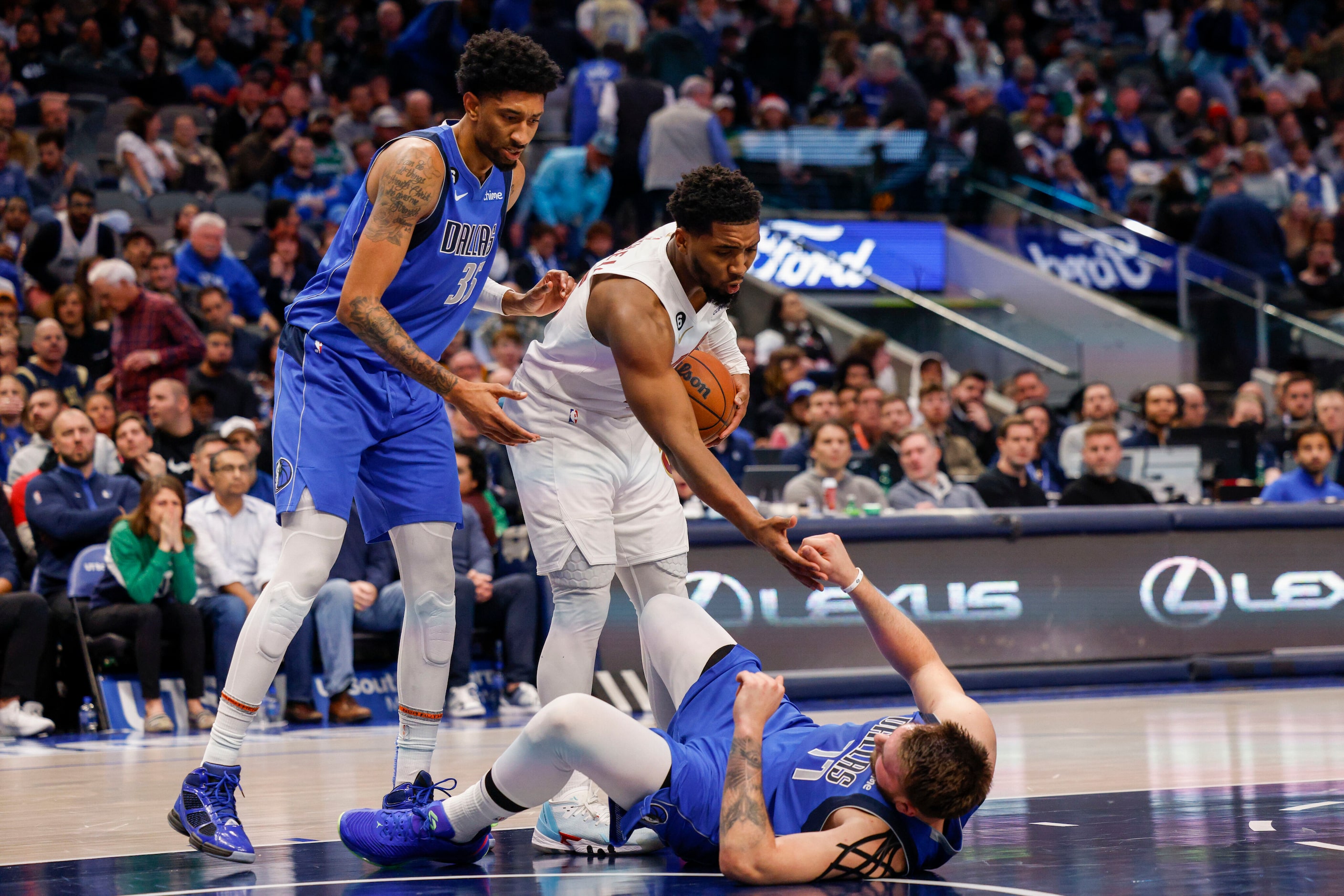 Cleveland Cavaliers guard Donovan Mitchell (45) helps Dallas Mavericks guard Luka Doncic...