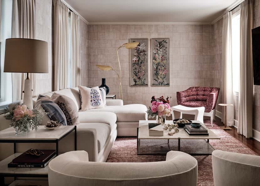 Living space with taupes on the sofa, walls and chairs, and warm reds on another chair, the...