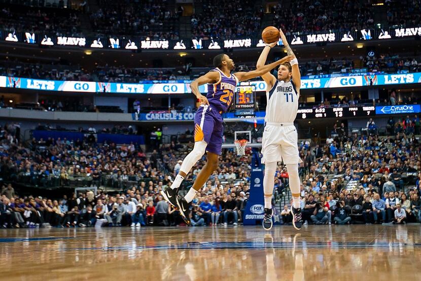 Dallas Mavericks forward Luka Doncic (77) shoots a 3-pointer over Phoenix Suns forward Mikal...