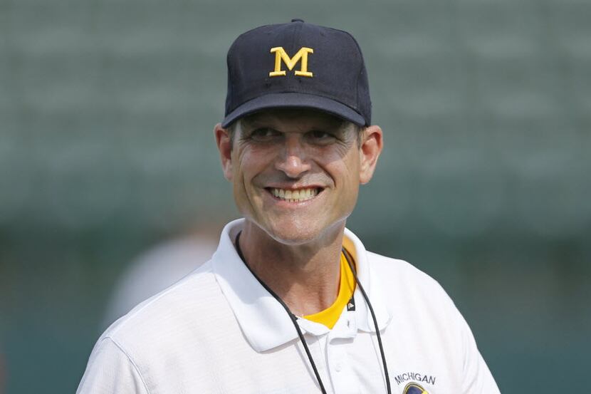 Michigan Wolverines head coach Jim Harbaugh smiles as he leads the Showtyme Elite Football...