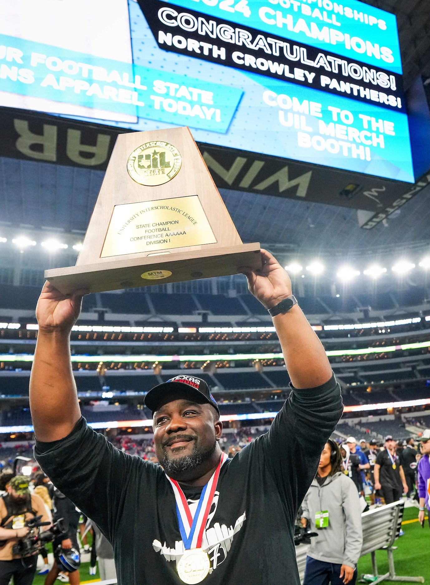 North Crowley head coach Ray Gates lifts the championship trophy toward the crowd after a...