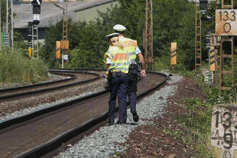 Police officers walk along train tracks in Wuerzburg southern Germany on July 19, 2016 a day...
