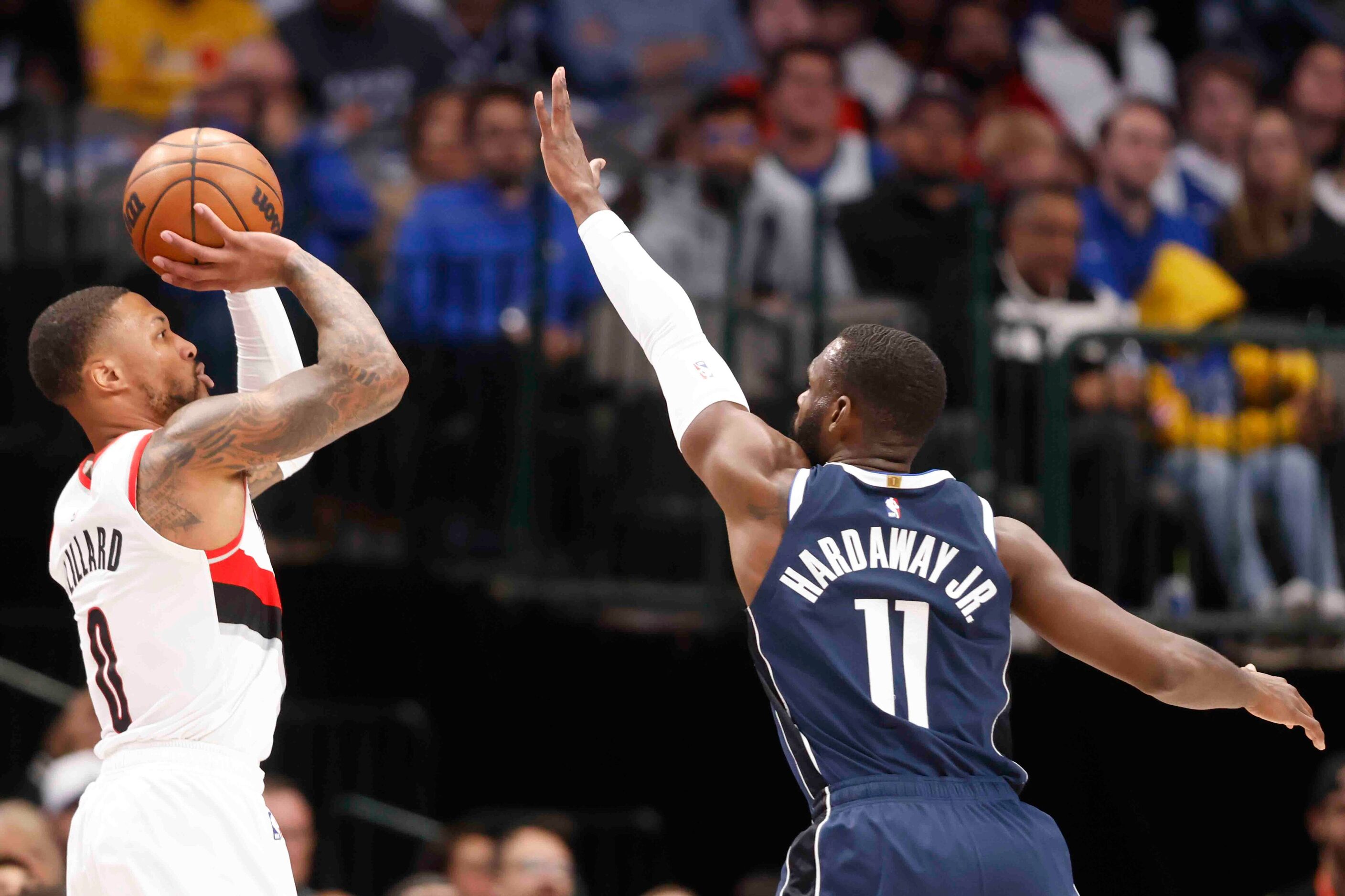 Portland Trail Blazers guard Damian Lillard (0) shoots a three pointer over Dallas Mavericks...