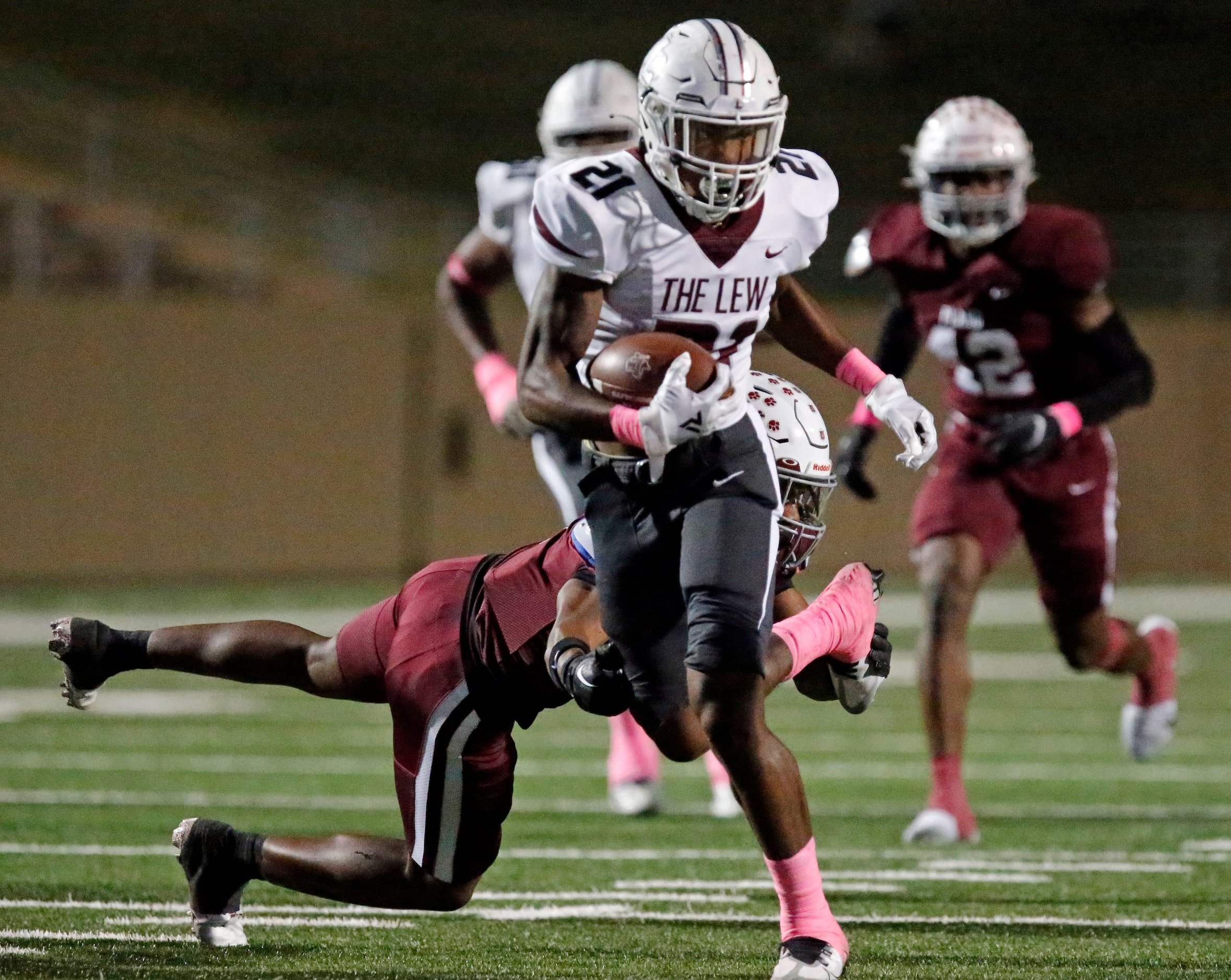 Lewisville High School running back Viron Ellison (21) breaks a tackle attempt by Plano...