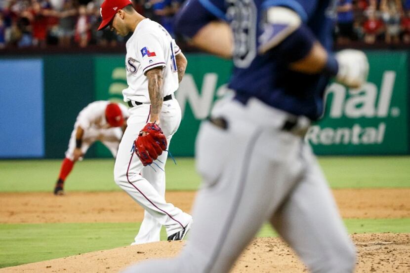 Texas Rangers relief pitcher Matt Bush and second baseman Rougned Odor hang their heads as...