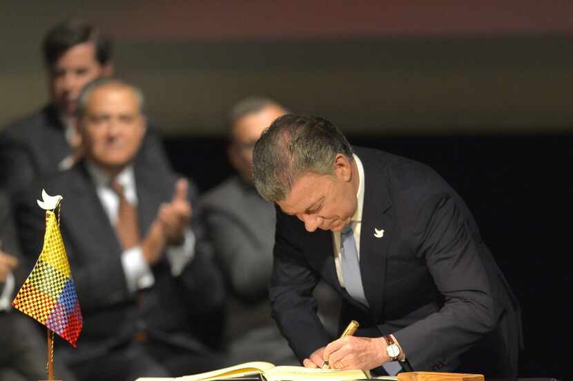 El presidente colombiano Juan Manuel Santos firma el histórico acuerdo de paz entre el...