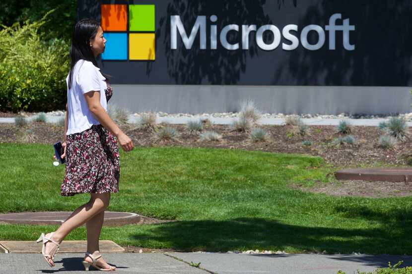 A pedestrian walks a sign on Microsoft Headquarters campus July 17, 2014 in Redmond, Wash....