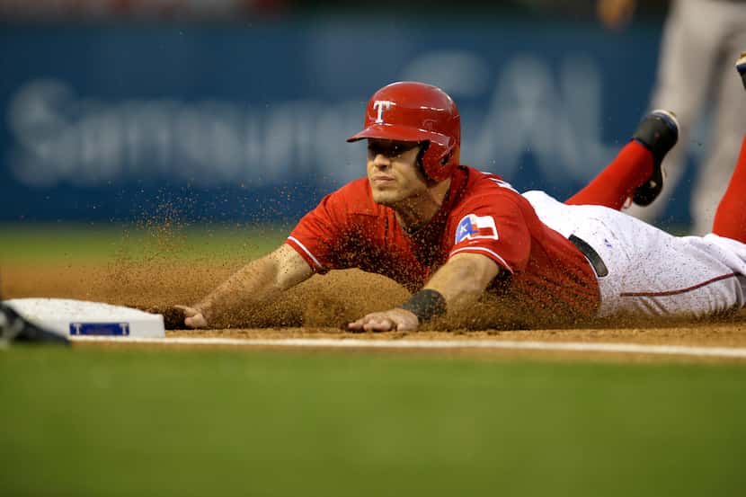 Texas Rangers' Ian Kinsler (5) slides safely into third on a Elvis Andrus double against the...