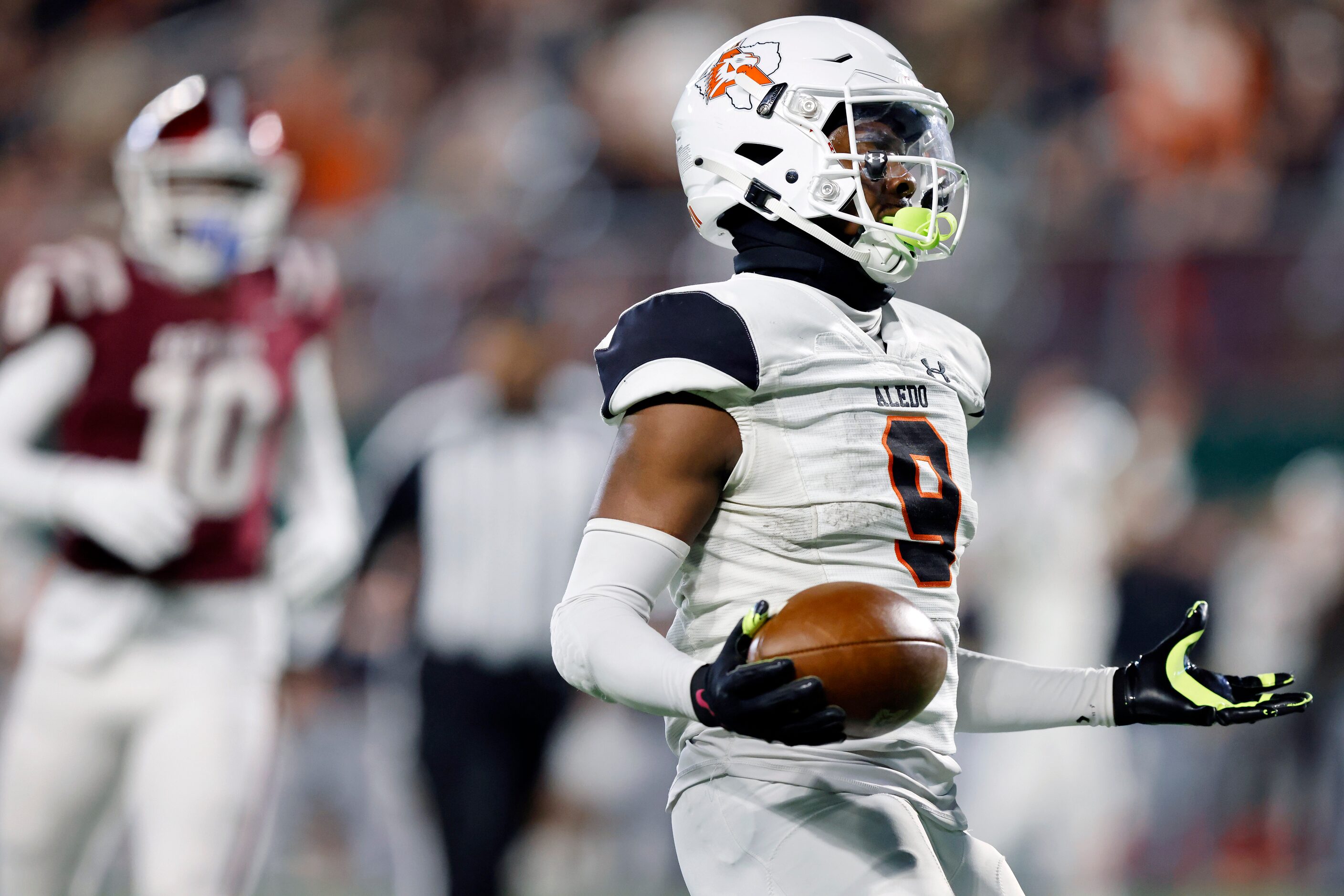 Aledo running back Raycine Guillory (9) holds out his hands as he crosses the goal line for...