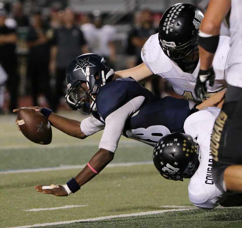 Frisco Lone Star quarterback Jason Shelley (18) is tackled after running with the ball in...