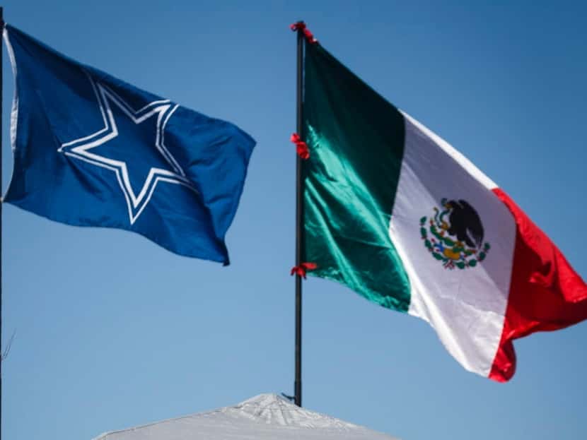 The flag of Mexico flies next to the team flag as Dallas Cowboys fans tailgate before an NFL...