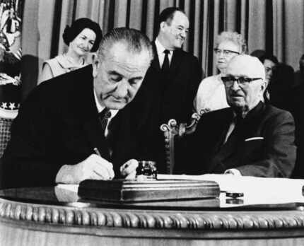 In this July 30, 1965 file photo, President Lyndon Johnson signs the Medicare Bill into law...