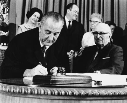 In this July 30, 1965 file photo, President Lyndon Johnson signs the Medicare Bill into law...