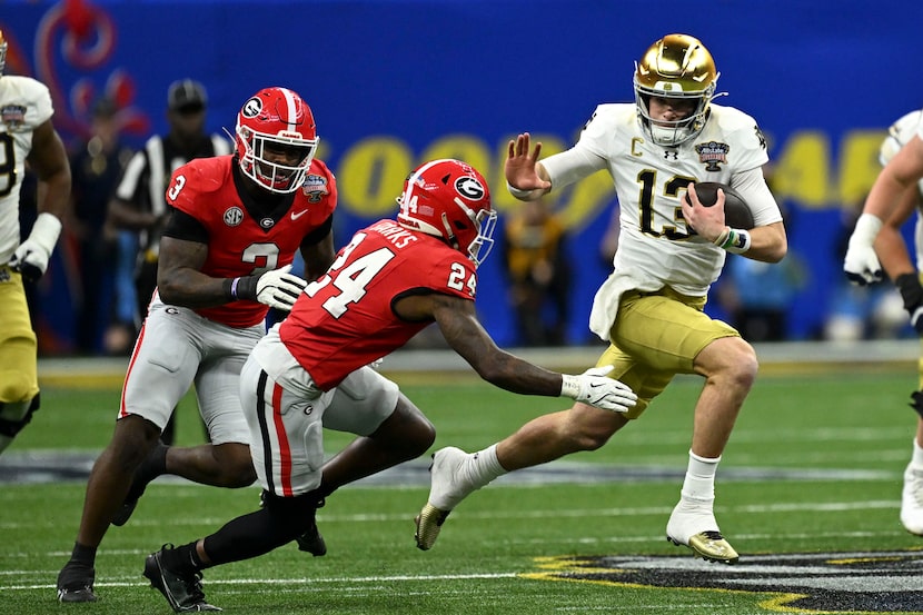 Notre Dame quarterback Riley Leonard (13) runs from Georgia defensive back Malaki Starks...