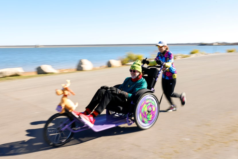 Mary Keeffe, pushes Troy Pruett as they train for the BMW Dallas Marathon, on Wednesday,...