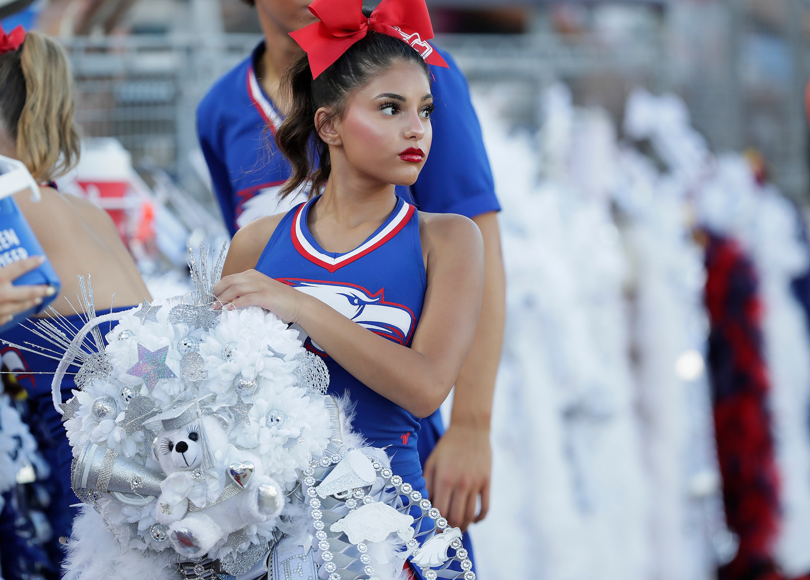 Kara Ellison, varsity cheerleader for Allen High School, looks for a space to hang her...