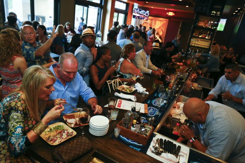 People eating during the opening party of Hickory, Kent Rathbun's new restaurant in Plano...