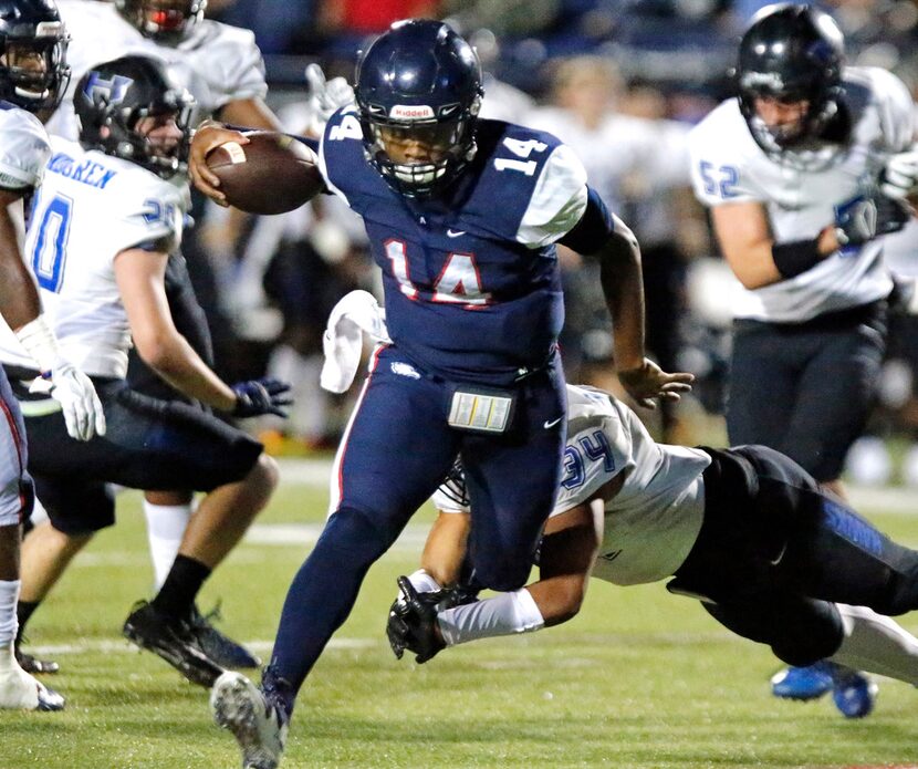 Allen High School quarterback Grant Tisdale (14) escapes Hebron High School defensive back...